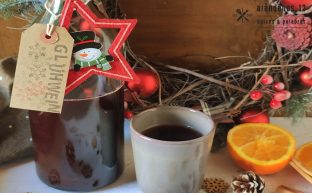 Botella vino caliente con taza y adornos navideños