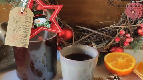 Botella vino caliente con taza y adornos navideños