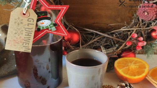 Botella vino caliente con taza y adornos navideños