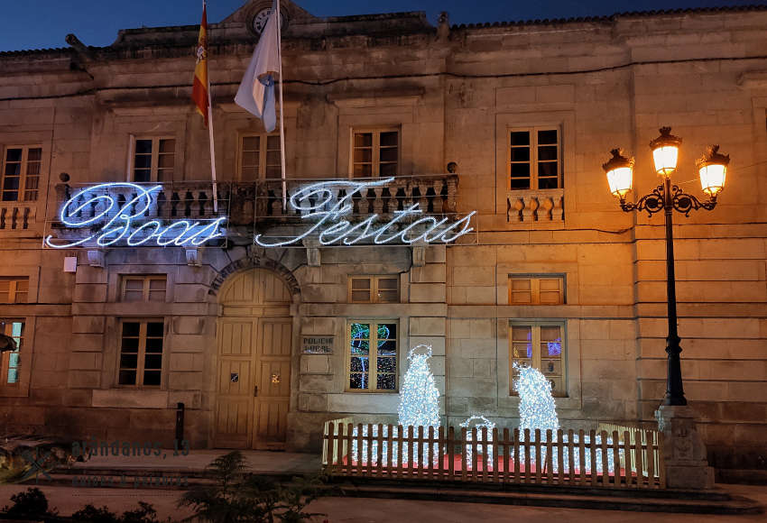 Edificio con luces que dicen Boas Festas y nacimiento de Belén de luces