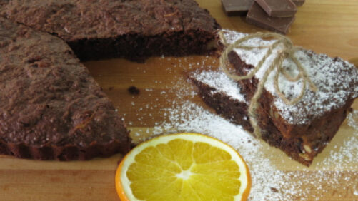 Brownie cortado con azúcar glas y una rodaja de naranja