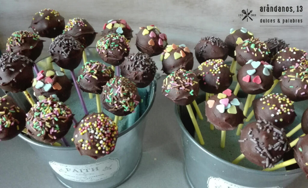 Dos cubos de metal con cakepops de chocolate adornados