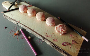 macarons sobre una tabla con lápices y virutas de colores